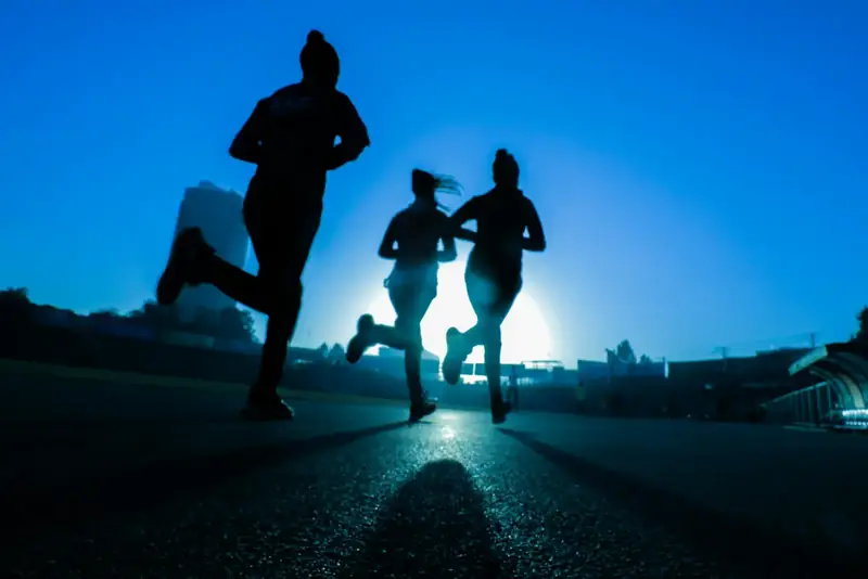 Tres personas corriendo al amanecer